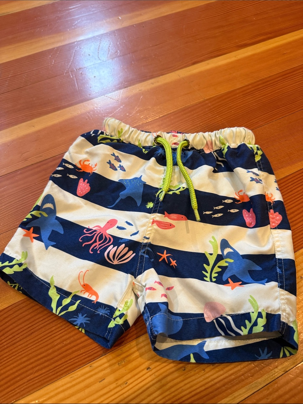 Baby Boden Navy Blue and White Striped Swim Shorts with Neon Green Drawstring